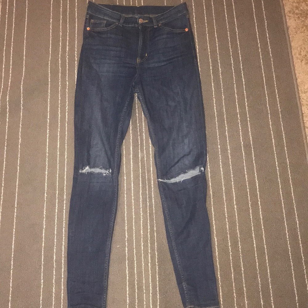 Dark blue knee ripped jeans.